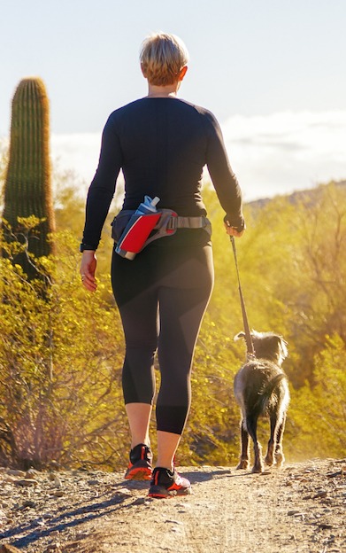Woman walking a small dog in the desert